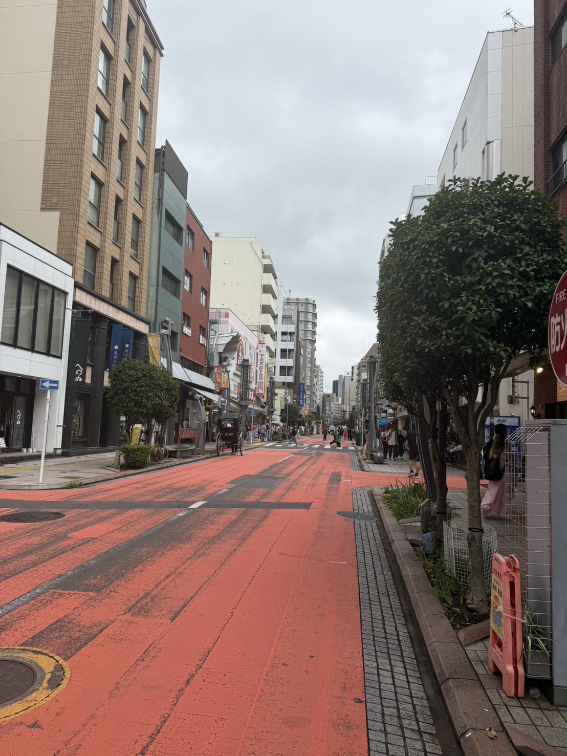 曇り空の浅草の街並みと赤い道路