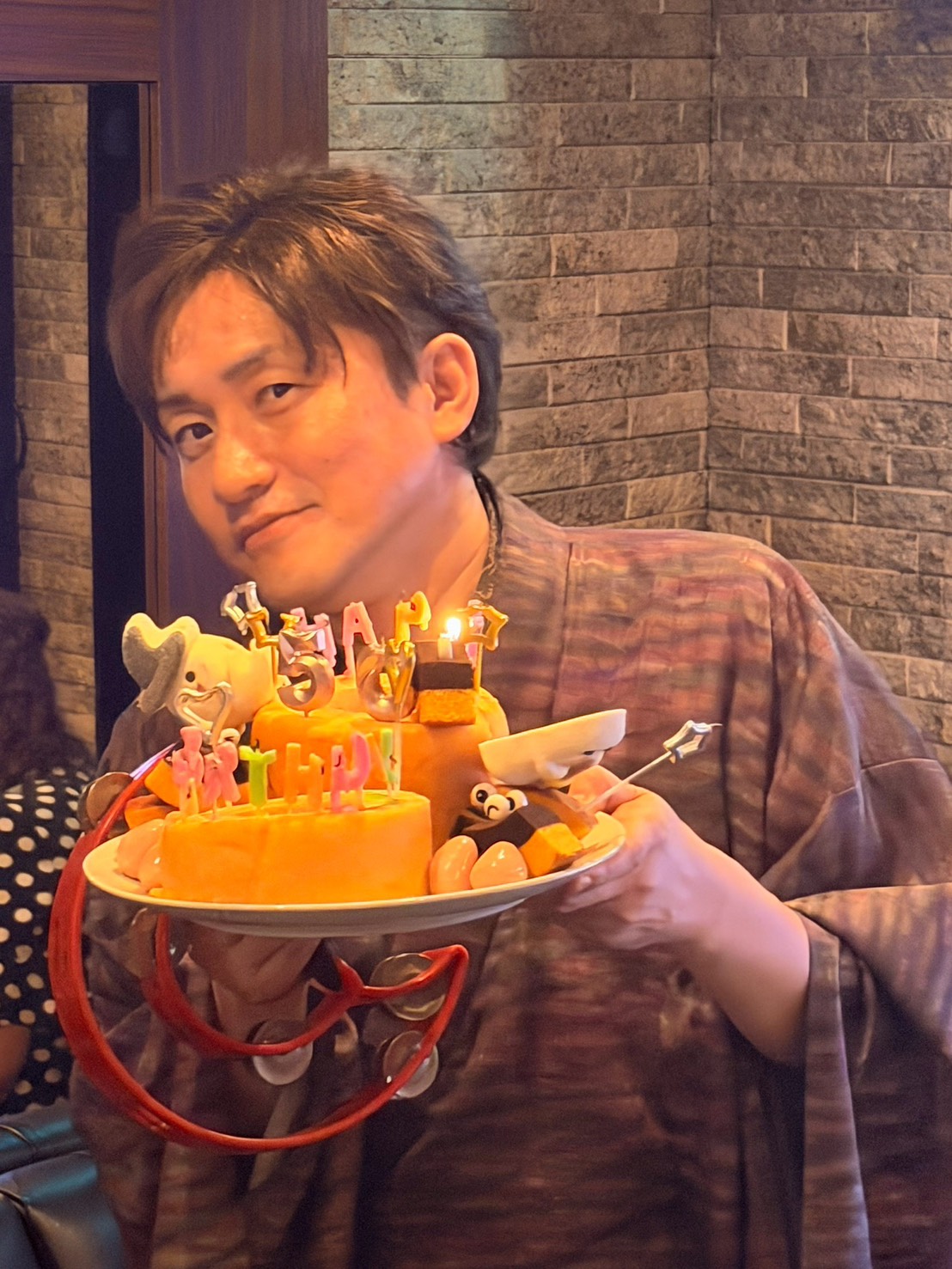 誕生日ケーキを持つ安永店長